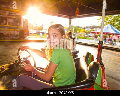 Mädchen, die ein Juwel in einem Vergnügungspark fahren Stockfoto