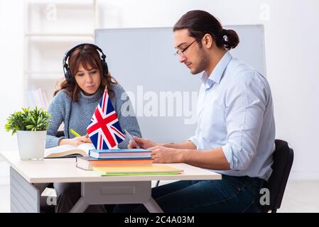 Junger Schüler und männlicher englischlehrer im Klassenzimmer Stockfoto