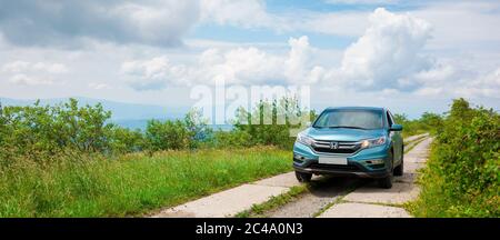 Mnt. runa, ukraine - 22. JUN 2019: Cyan honda cr-V suv auf der Bergstraße. Erkunden Sie das Wildnis-Konzept. Grat in der Ferne. Sonniges Wetter. clo Stockfoto