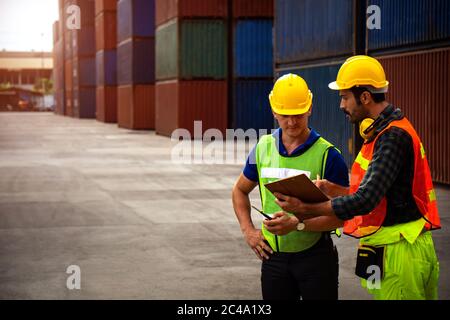 Zwei Industriearbeiter diskutieren über die Jobplanung in der Schifffahrt. Stockfoto