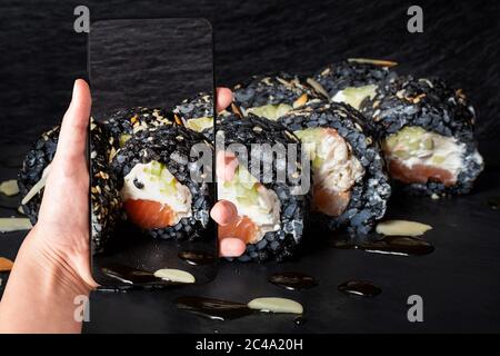 Bestellen Sie Sushi-Set mit Handy-App. Online-Konzept für die Lebensmittelzustellung. Virtuelle Realität Stockfoto