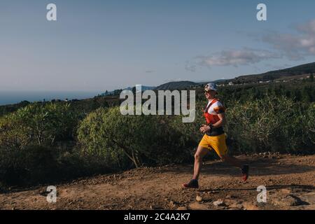 Junger Erwachsener Mann in Sportbekleidung laufen im Trail Outdoor, Läufer Mann Joggen auf der Straße Stockfoto