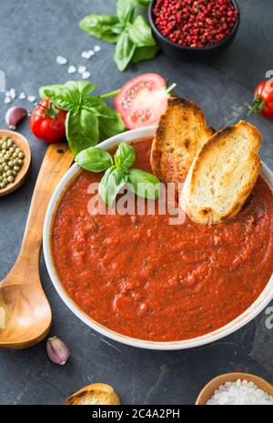 Frische hausgemachte Tomatensuppe in der Schüssel auf Steingrund Stockfoto