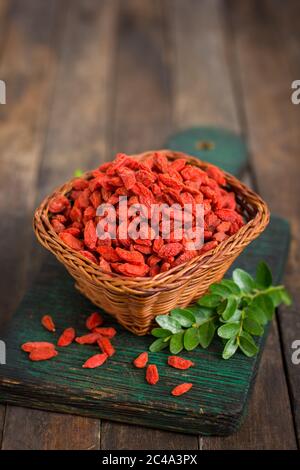 Goji Beeren im Korb auf dem rustikalen Tisch Stockfoto