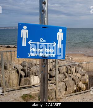 Zwei Meter halten Abstand Sozial distanzierenden Zeichen am highcliffe Strand, bournemouth. Stockfoto