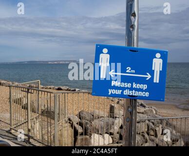 Zwei Meter halten Abstand Sozial distanzierenden Zeichen am highcliffe Strand, bournemouth. Stockfoto