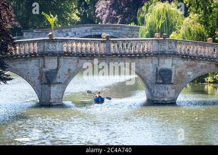 Cambridge, Großbritannien. Juni 2020. Ein Mann genießt die Hitzewelle in einem Kajak auf dem River Cam von Clare Bridge, wenn die Temperaturen über 30 Grad Celsius steigen. Der Fluss ist sehr ruhig wegen der Schließung der meisten Unternehmen, die während der Coronavirus-Sperre. Es gibt auch Warnungen vor hohen UV-violetten Strahlen in der weniger verschmutzten Sommerwetter. Kredit: Julian Eales/Alamy Live Nachrichten Stockfoto