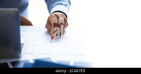 Planung, Meeting, Terminkonzept. Nahaufnahme Hand des Geschäftsmanns Putting Pins auf calenda für die Planung und Buchung von Termin oder Meeting Stockfoto