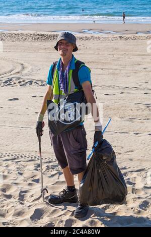 Ratsarbeiter, der am heißesten Tag des Jahres während der Hitzewelle am Bournemouth Beach, Dorset UK im Juni Müll aufsammeln konnte Stockfoto
