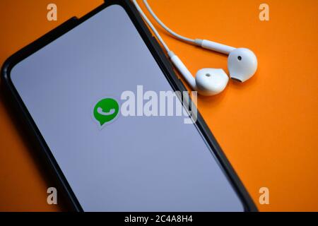 TIKAMGARH, MADHYA PRADESH, INDIEN - 17. DEZEMBER 2019: WhatsApp-Logo auf Smartphone-Bildschirm mit Kopfhörern. Stockfoto