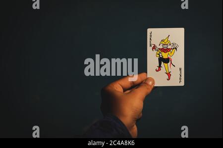 TIKAMGARH, MADHYA PRADESH, INDIEN - 15. DEZEMBER 2019: Hand hält Joker Spielkarte. Stockfoto