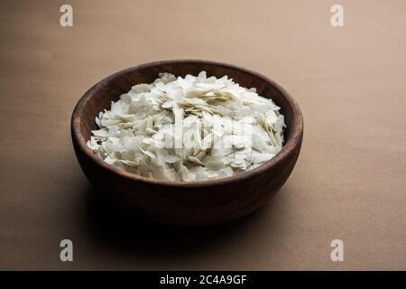 Roher, abgeflachte Reis oder dicke oder dünne Reisflocken für Namkeen Chivda Snacks oder Aloo Poha für indisches Frühstück, serviert in einer Schüssel Stockfoto