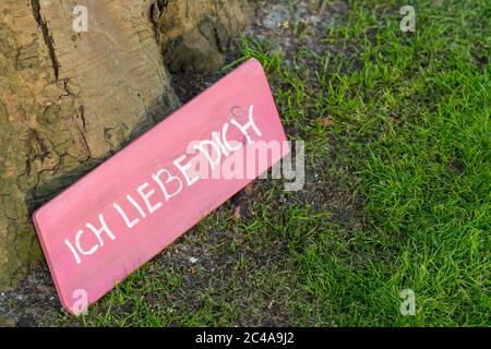 Rosa Schild am Fuß eines Baumes mit der Aufschrift 'Ich liebe dich' Stockfoto