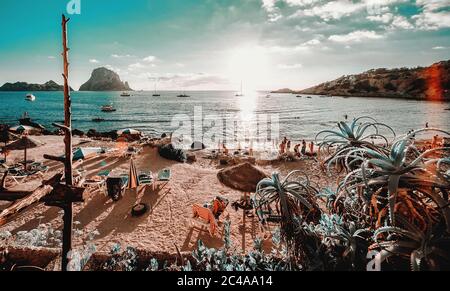 Blick auf den Strand Cala d'Hort auf Ibiza. Unkenntlich Touristen entspannen hängen an der malerischen berühmten Küste mit Es Vedra Felsen malerischen Blick Stockfoto