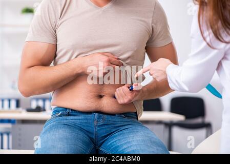 Männlicher Diabetiker, der einen jungen Arzt besucht Stockfoto