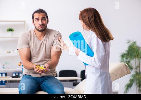 Männlicher Diabetiker, der einen jungen Arzt besucht Stockfoto