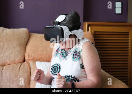 Frau hat Angst, was sie in einer Virtual Reality Brille sagt. Neues Technologiekonzept. Stockfoto