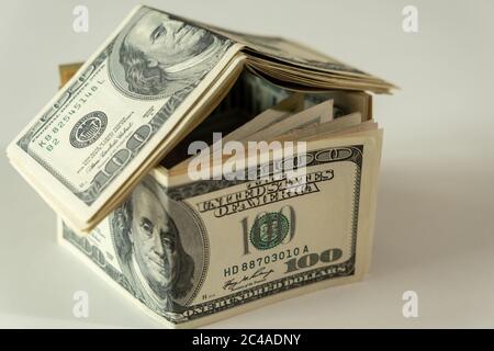 Mini-Haus der Dollar-Banknote. Konzept der Investitionsimmobilie, Hypothek Konzept. Investitionsrisiko und Unsicherheit
