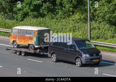 1960s 60s 60er Jahre Stil rostig alt grün antik Split-Screen VW Volkswagen kombi Scheune finden. 1962 Volkswagen Typ 2 Van Bus, Pop Top, Caddy, Transporter, Wohnmobil, kombi, Kombi, Wohnmobil, Wohnmobil, Umbau, Vee Dub, Umbauten, Mikrobus, Bus, Camper, Verrostete Volkswagen-Wohnmobile, die von einem ausländischen europäischen VW-Transporter der EU auf der Autobahn M6 in Großbritannien auf einem Anhänger abgeschleppt werden. Stockfoto