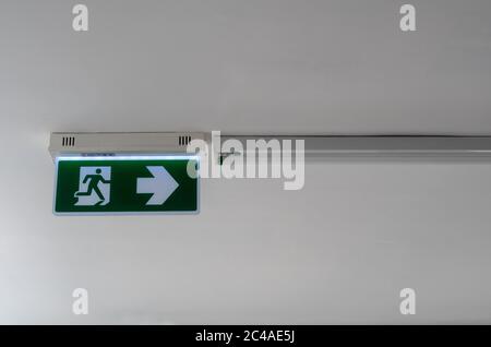 Ausstiegsschilder, Feuerausgänge und Pfeile, die den Weg auf die Lichtschilder an der Decke der Korridore im Gebäude weisen. Stockfoto
