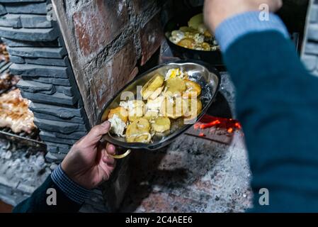 Mann kocht Spiegeleier mit Kartoffeln in der Pfanne, Draufsicht, selektiver Fokus. Stockfoto