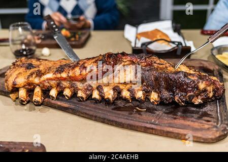 'Parrillada' Argentinischer Grill auf Live-Kohle (keine Flamme), Rindfleisch 'Asado', Brot, 'Chorizo' und gegrillte Rippchen mit einem heißen Rack, Nahaufnahme. Stockfoto