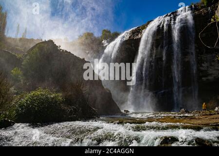 Mann, der gegen den großen Wasserfall in Tortum läuft. Entdecken Sie die Schönheit und Tierwelt der Welt. Mann auf einem großen Wasserfall Stockfoto