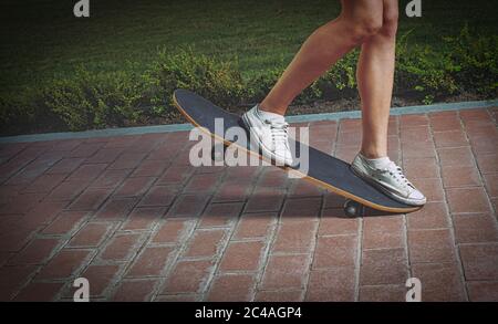 Mädchen macht Skateboard Trick auf der Parkspur, Side vie Schuss mit Copyspace. Stockfoto