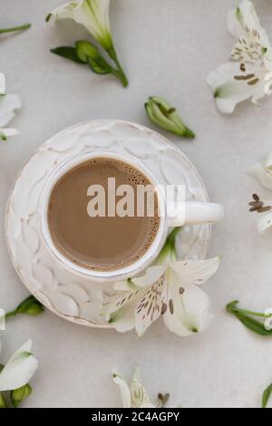 Nahaufnahme des Kaffees in einer weißen rustikalen Tasse auf hellgrauem Hintergrund. Stockfoto