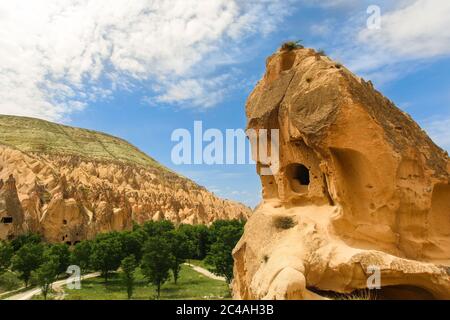 Hoodoos von Kappadokien. Zeltfelsen, die von Wind und Wasser im Laufe der Zeit in der Geschichte geschnitzt wurden. Wolken und Gras. Höhlen von Kappadokien, Nevsehir / Türkei Stockfoto