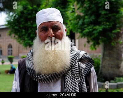 Srinagar, Indien - JUNI 20: Portrait alter Mann mit langem weißen Bart trägt den traditionellen Schal und den Hut in der Moschee am 20. Juni 2017 Stockfoto