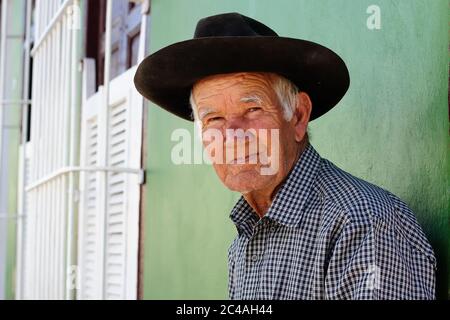 Trynidad , KUBA - 08. NOVEMBER: Ein armer Mann mit Hut sitzt auf einer Bank vor seinem Haus in Trinidad, Kuba 08. November 2016 Stockfoto