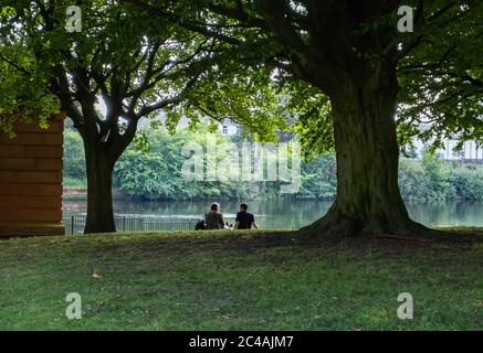 Glasgow, Schottland, Großbritannien. Juni 2020. Wetter in Großbritannien. Menschen sitzen auf dem Gras am Ufer des Flusses Clyde am heißesten Tag des Jahres in Glasgow Green. Kredit: Skully/Alamy Live Nachrichten Stockfoto