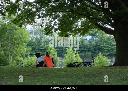 Glasgow, Schottland, Großbritannien. Juni 2020. Wetter in Großbritannien. Menschen sitzen auf dem Gras am Ufer des Flusses Clyde am heißesten Tag des Jahres in Glasgow Green. Kredit: Skully/Alamy Live Nachrichten Stockfoto