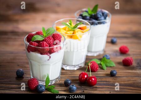 Frischer Fruchtjoghurt mit frischen Beeren und Pfirsichen Stockfoto