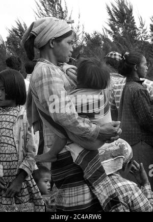 Mutter hält Kind während Rauchen einer Cheroot-Pfeife in Menschenmenge warten auf einen Bus 1959 Menschen Street scene, Baguio City die Philippinen Stockfoto