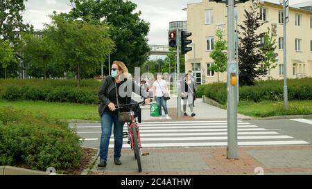 Coronavirus Maske Gesicht Umdrehen Menschen Menge Frau Ampel Fußgänger Überqueren Radfahrer Fahrrad, öffentliche Verkehrsmittel Prävention gegen Risiko covid- Stockfoto