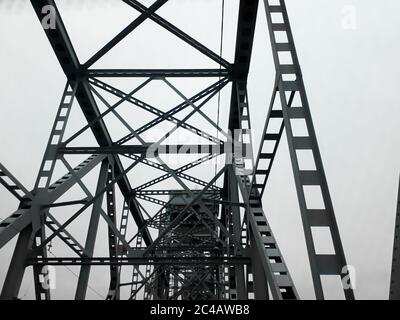 Metallkonstruktion der Eisenbahnbrücke mit dem aufsteigenden Mittelteil für die Durchfahrt von Schiffen. Blick von unten vom Fenster des Autos. Architektur, Designelemente Stockfoto