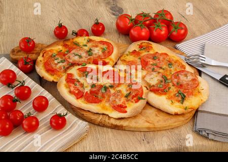 Schwäbische Küche, Dinnnete, Dennete, Schwäbische Pizza mit Tomaten, Käse und Basilikum, serviert auf Holztellern, Deutschland Stockfoto