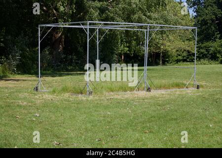 Cricket Käfig ohne Netz im Feld mit Bäumen im Hintergrund Stockfoto