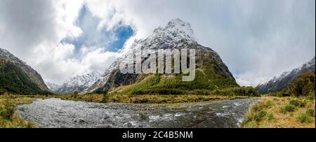 Tal mit schneebedeckten Bergen, Hollyford River, Fiordland National Park, Te Anau, Southland, South Island, Neuseeland Stockfoto