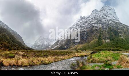 Tal mit schneebedeckten Bergen, Hollyford River, Fiordland National Park, Te Anau, Southland, South Island, Neuseeland Stockfoto