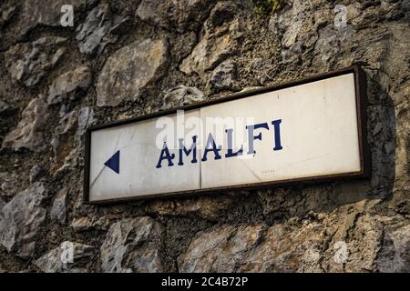 Nahaufnahme eines alten Straßenschildes von Ravello, der die Richtung nach Amalfi anzeigt. In der Provinz Salerno, an der Amalfiküste. Stockfoto