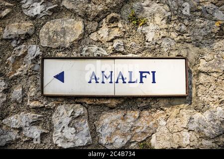 Nahaufnahme eines alten Straßenschildes von Ravello, der die Richtung nach Amalfi anzeigt. In der Provinz Salerno, an der Amalfiküste. Stockfoto