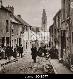 Eine Straßenszene aus den frühen 1920er Jahren in Shandon, Cork City. Der Turm der St. Ann's Church kann man über den engen, überfüllten Straßen sehen. Ursprünglich fotografiert von Clifton Adams (1890-1934) für 'Ireland: The Rock Whence I Was Hewn', eine National Geographic Magazine-Spielfilm vom März 1927. Stockfoto