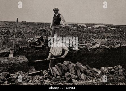 Eine Ansicht der frühen 1920er Jahre, in der die Einheimischen im Sommer mit einem Schlitten (Turfspaten) Rasen (oder Torf) für Winterbrände ausgraben. Ursprünglich fotografiert von A. W. Cutler (1875-1935) für 'Ireland: The Rock Whence I was Hewn', eine National Geographic Magazine-Spielfilm vom März 1927. Stockfoto