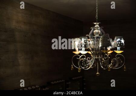 Nahaufnahme von antiken Kronleuchter mit großen gelben Glühbirnen.Runde großen Jahrgang Lampe auf schwarzem Hintergrund.Luxus großen Kronleuchter mit vielen Lampen und Stockfoto