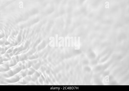 Nahaufnahme der entsättigte transparente klare ruhige Wasseroberfläche Textur mit Spritzern und Blasen. Trendy abstrakt Natur Hintergrund. Stockfoto