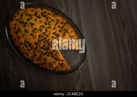 Hausgemachte leckere Kürbiskuchen mit Kürbiskernen bestreut. Es steht auf einem Holztisch. Draufsicht. Stockfoto