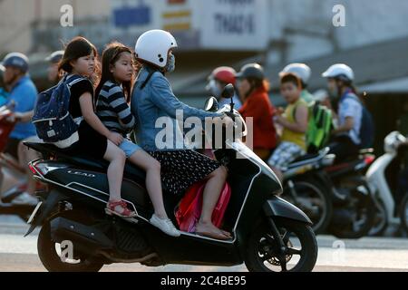 Mutter und Kinder reiten motorbile auf dem Weg zur Schule Stockfoto